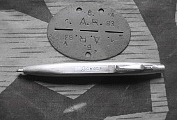 Známka dělostřelce a stříbrná propiska